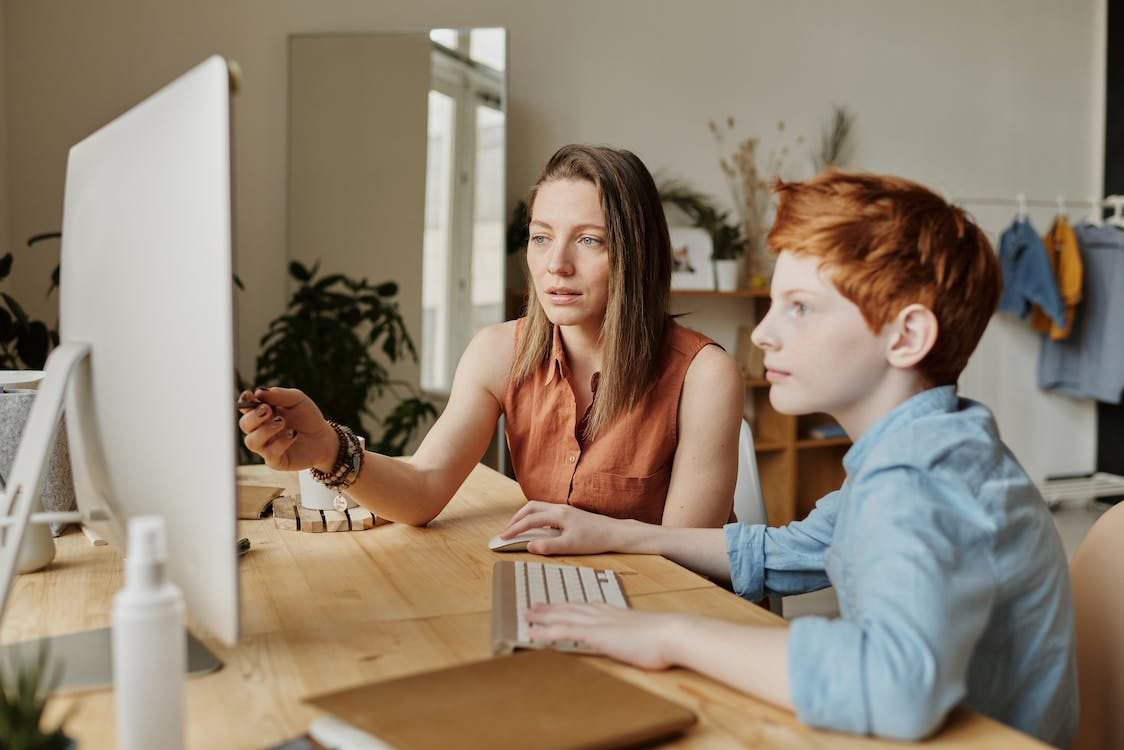 A boy and his mother using a computer together