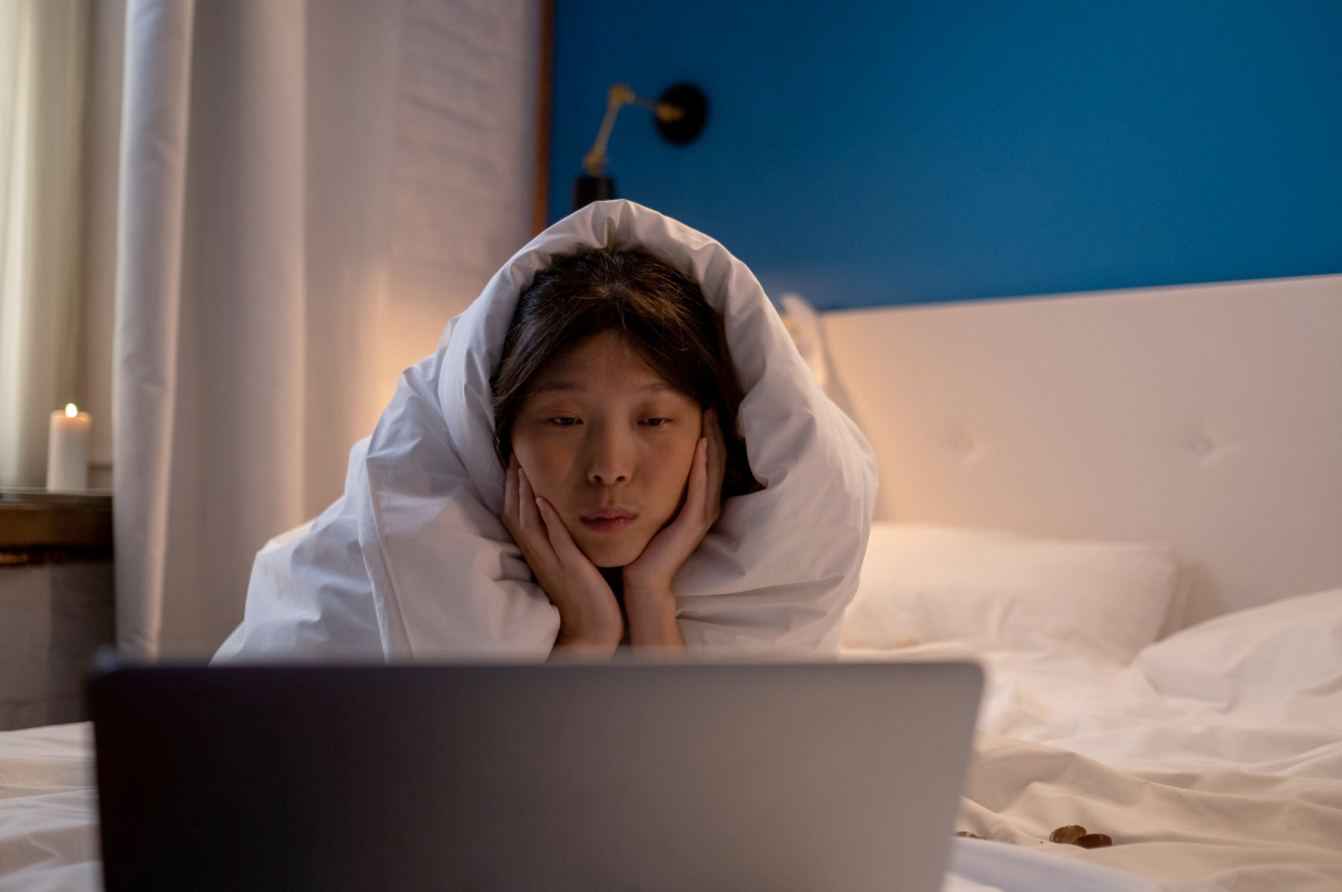 An image of a woman watching a movie on the laptop.