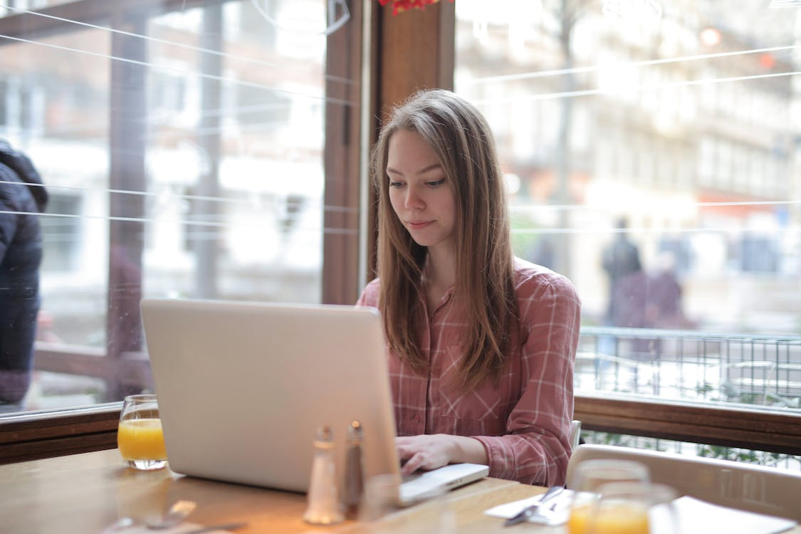 A woman using her public Wi-Fi on her laptop to send emails