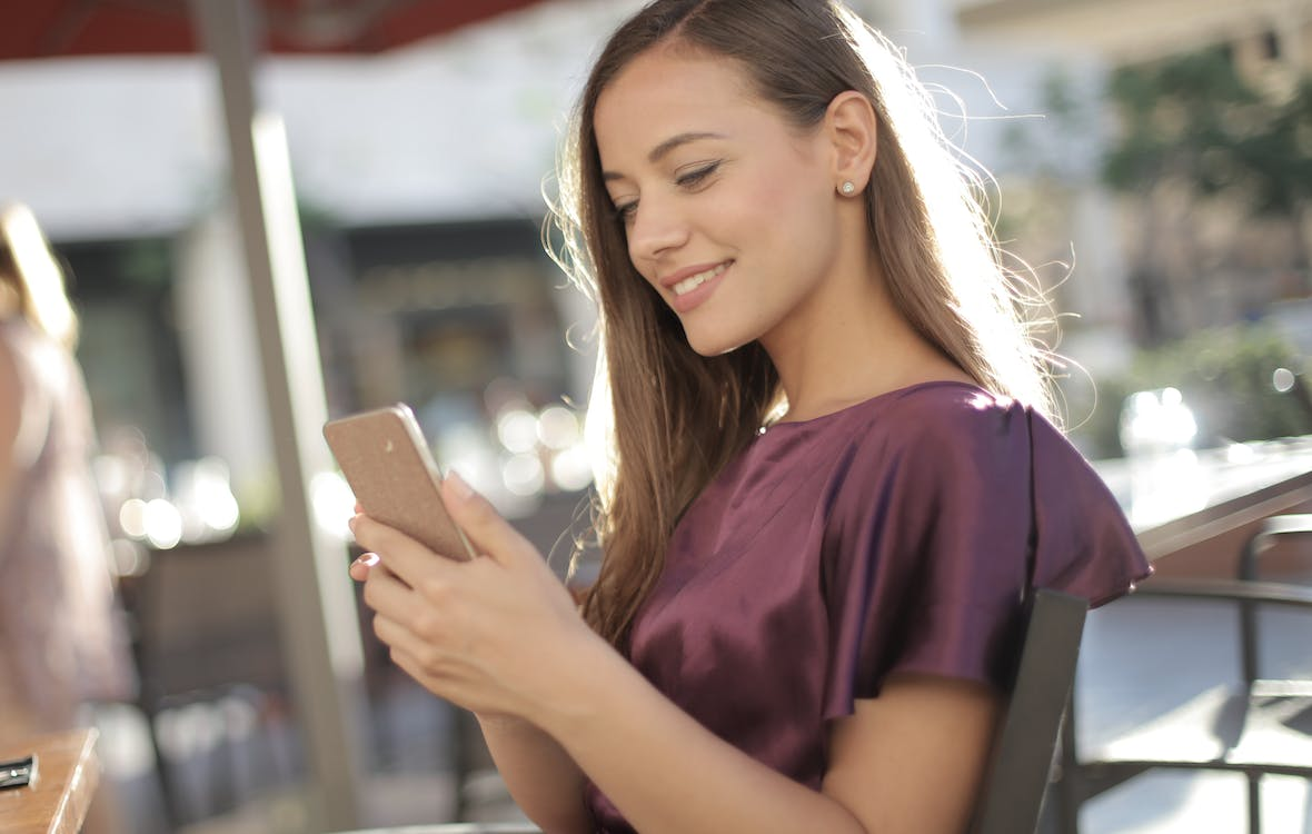 a woman using public Wi-Fi with VPN for Android to access social media on her phone .