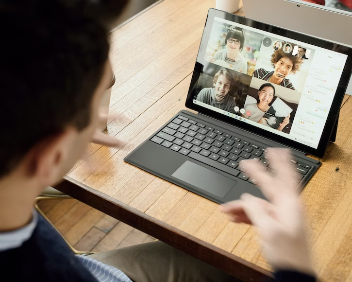 A man taking a Zoom meeting from his laptop