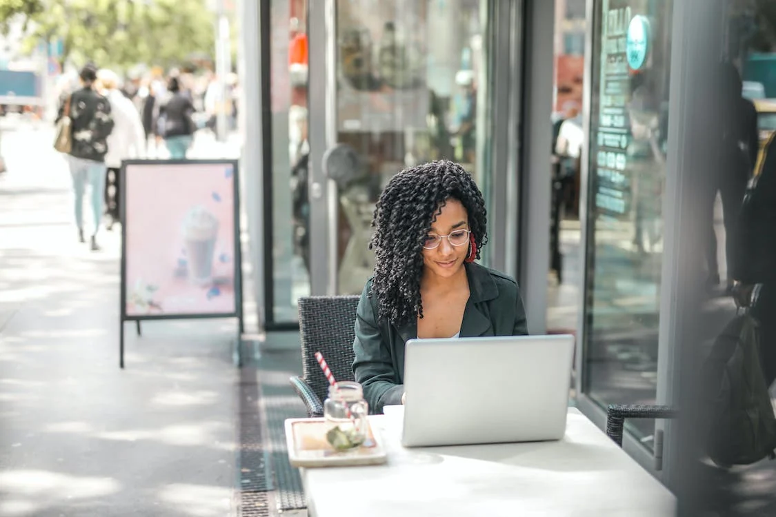 An IT professional working on her laptop in a cafe