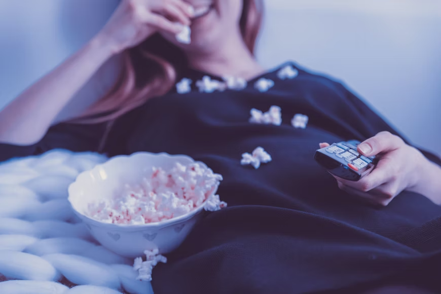  A girl eating popcorn while watching Netflix