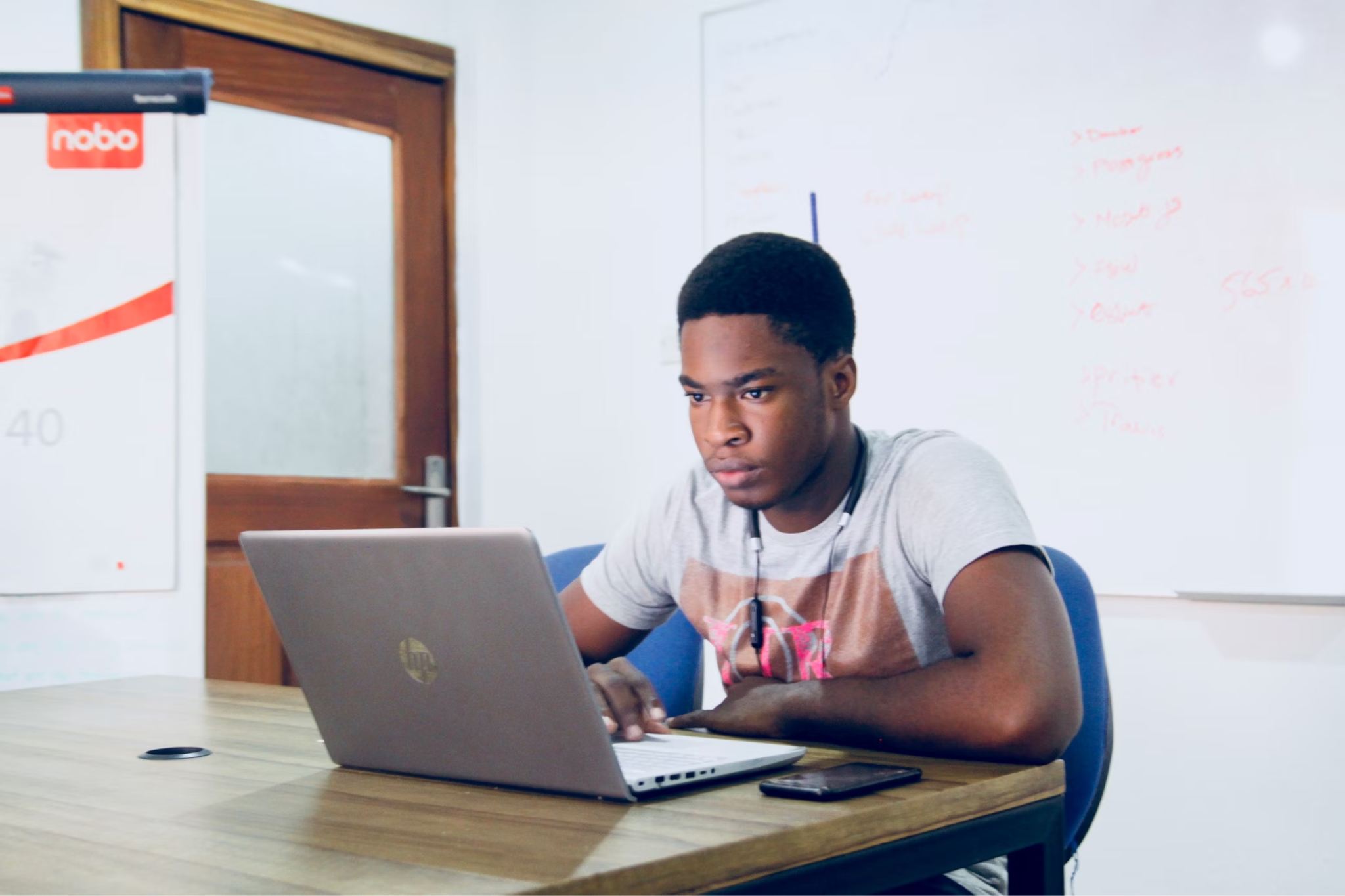 A college student using his laptop in a class