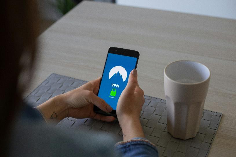 A person using a VPN connection on a smartphone while seated at a table