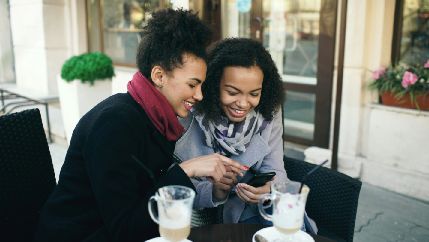 Two women looking at a smartphone